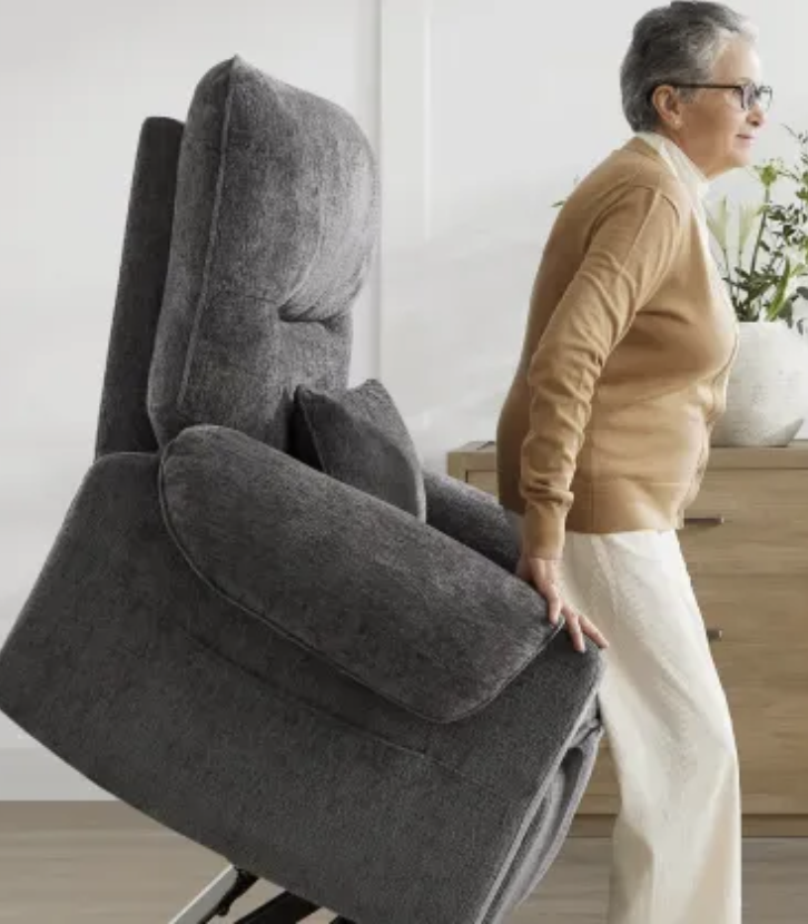 Woman standing with help from a gray power lift recliner